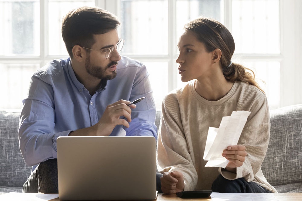 Муж и жена обсуждают вопрос оформления второй ипотеки за столом.