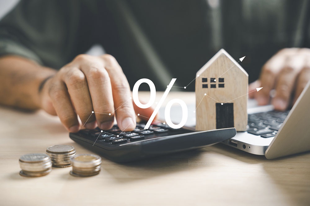 Рука нажимает на калькулятор для расчета второй ипотеки.