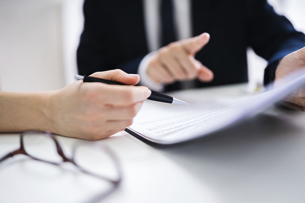 Человек подписывает доверенность, передавая полномочия.