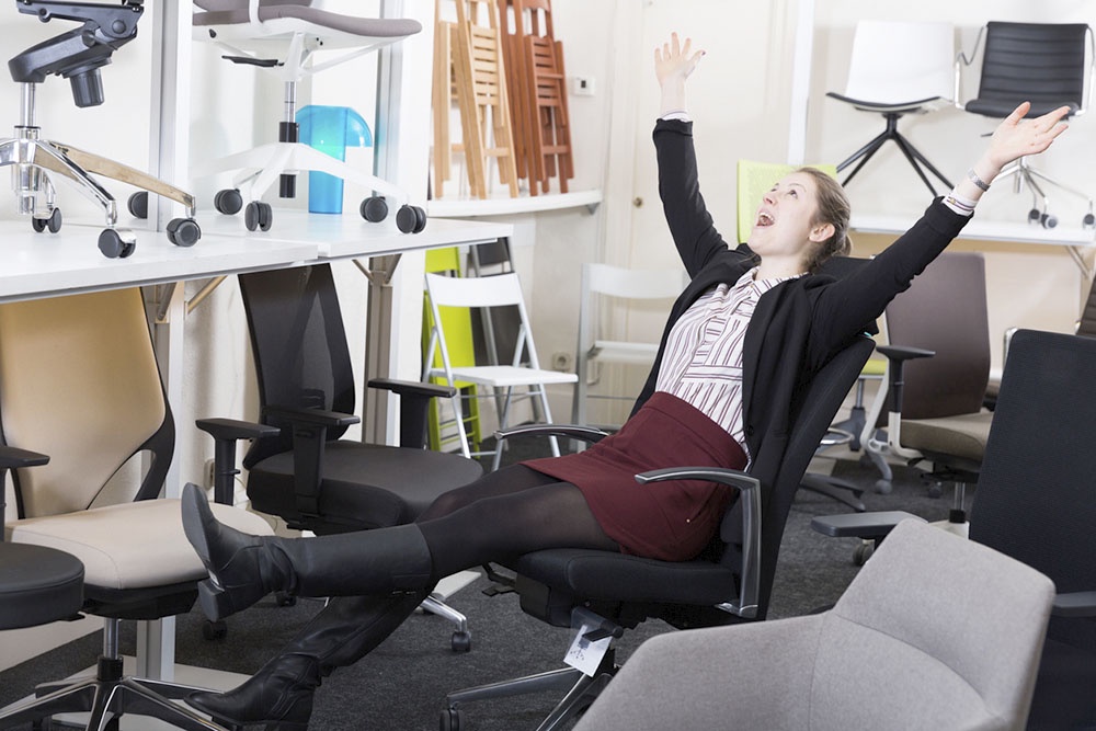 Женщина выбирает кресло для офиса.