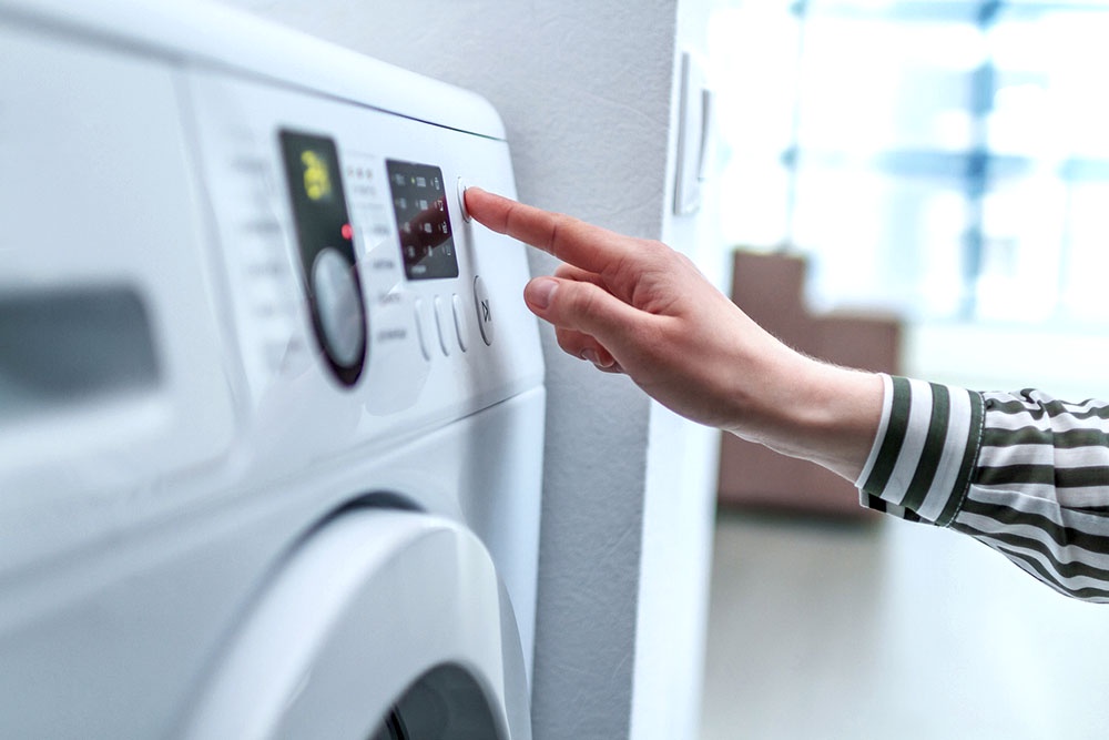 Выбор режима стирки на стиральной машинке.