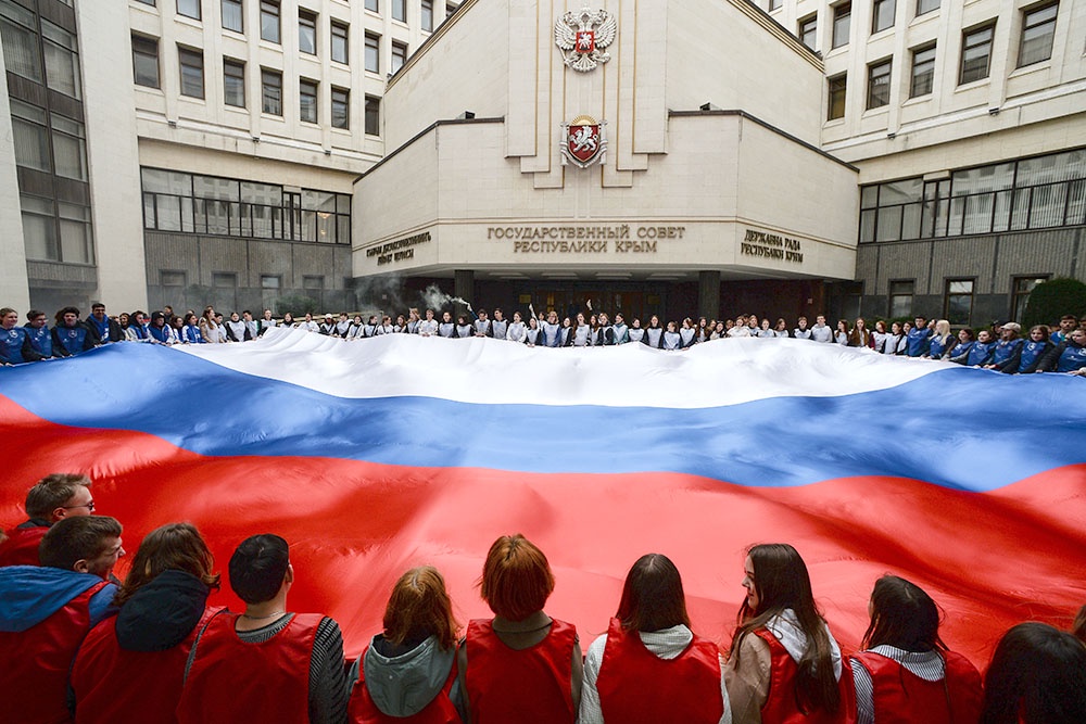 Участники акции, посвященной Дню воссоединения Крыма с Россией, перед Государственным Советом Республики Крым.
