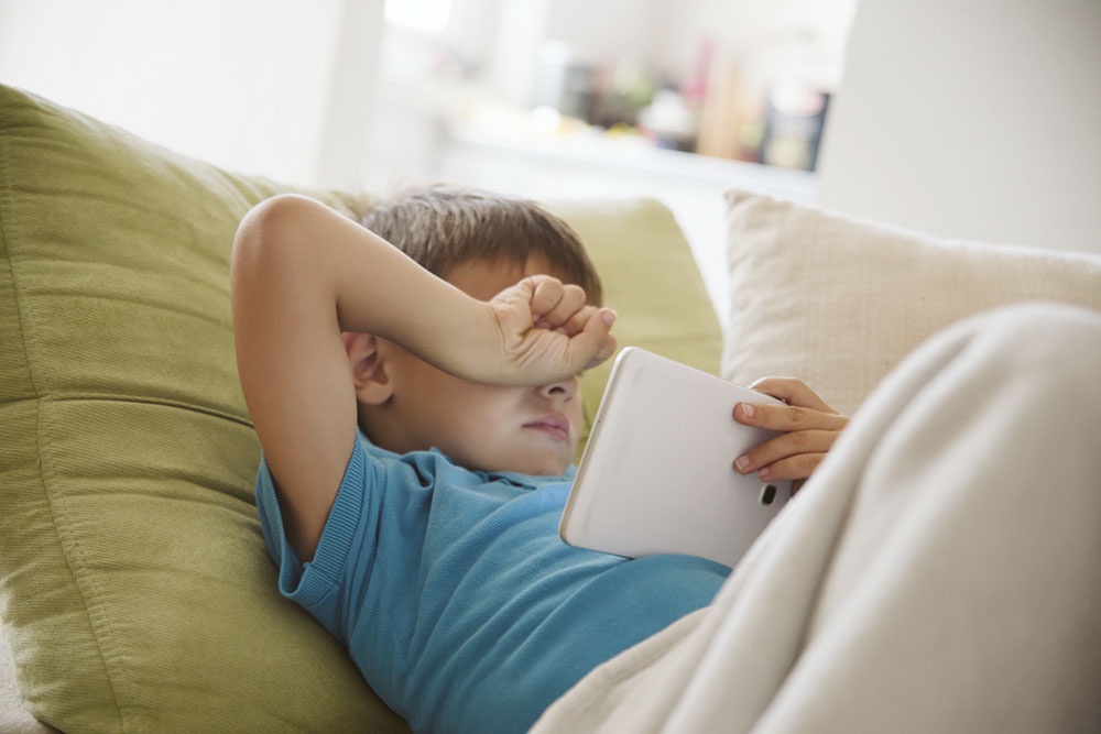 Ребенок устал и трет глаза.