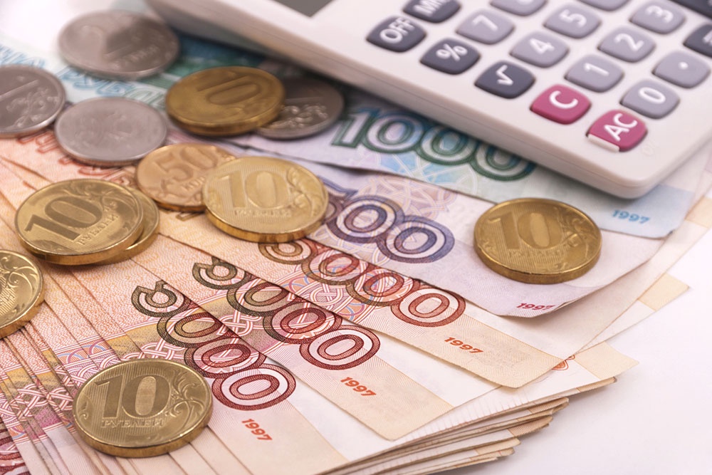 Концепт экономии за коммунальные, на столе рубли и калькулятор.