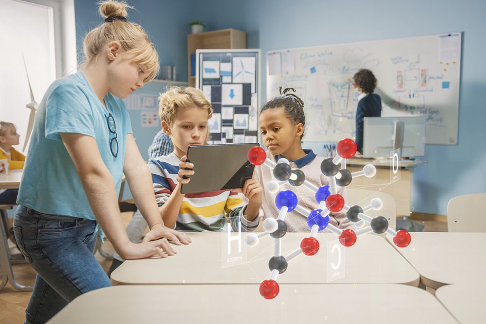 Деть на уроке с планшетом изучают химию, метафора дополненной реальности.