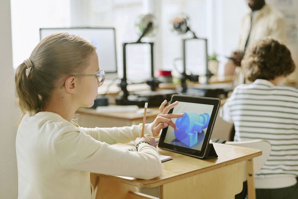 Школьница с планшетом работает на уроке.