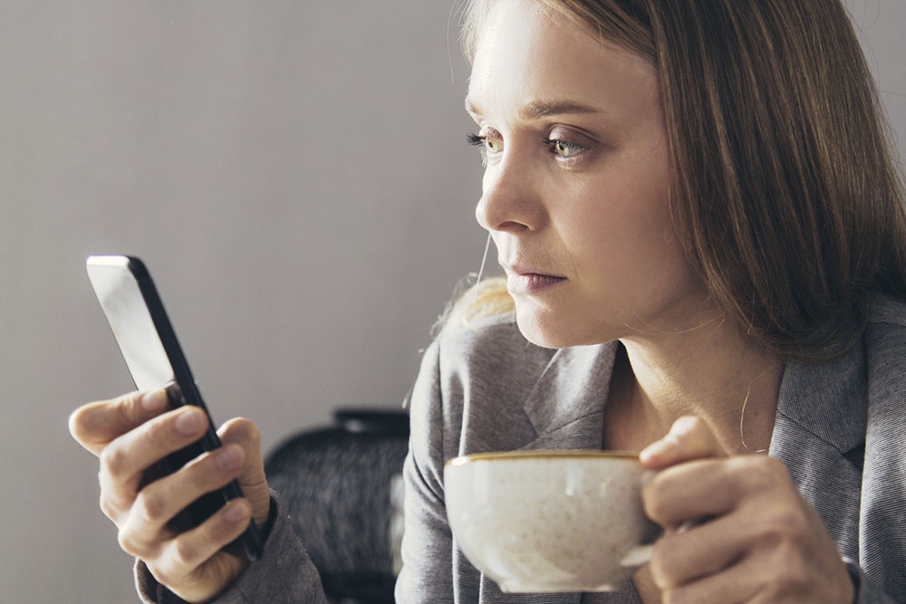 Женщина тревожно следит за соцсетями.