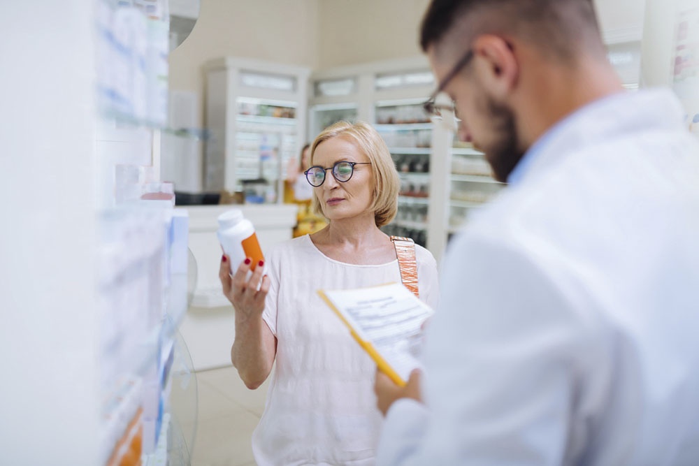 Женщина в аптеке выбирает пробиотик.