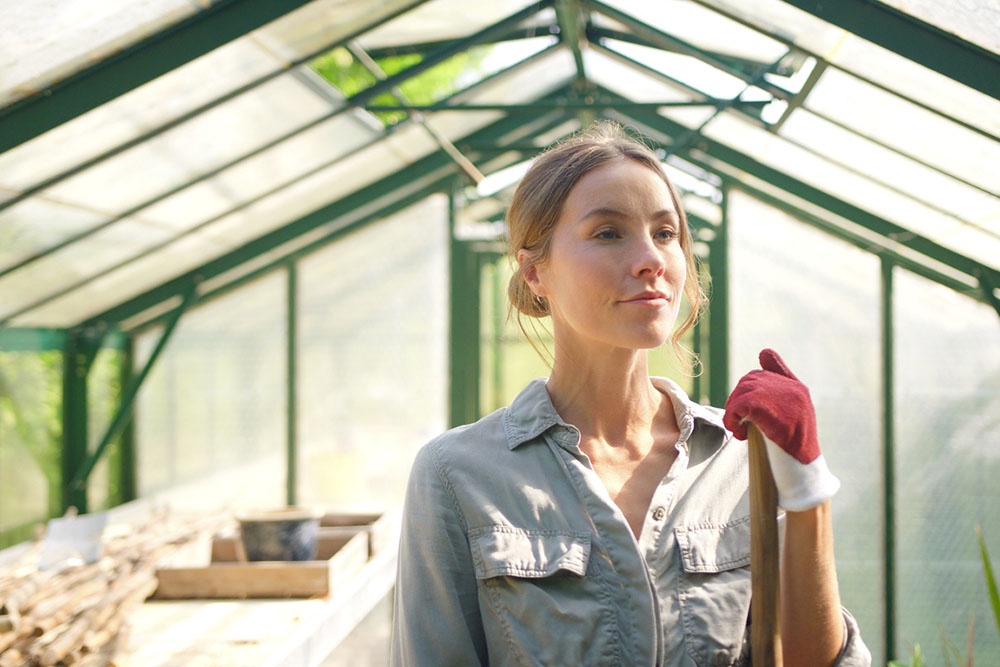 Женщина в теплице, готовится к началу дачного сезона.