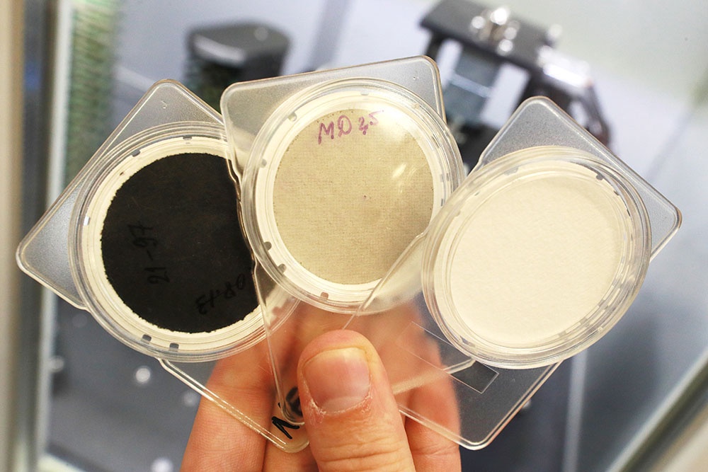 Образцы фильтров разного уровня загрязненности в лаборатории по проверке проб воздуха.