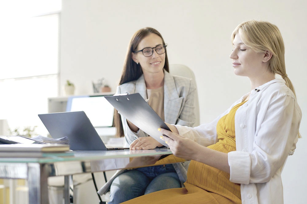 Беременная женщина в страховой компании, переоформляет полис ОМС, выбор страхователя по полису ОМС.