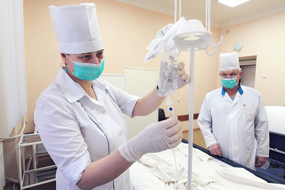 Медицинская сестра подготавливает лекарственные препараты для внутривенных инфузий в городской клинической больнице. Оказание помощи по ОМС в регионе, Тамбов.