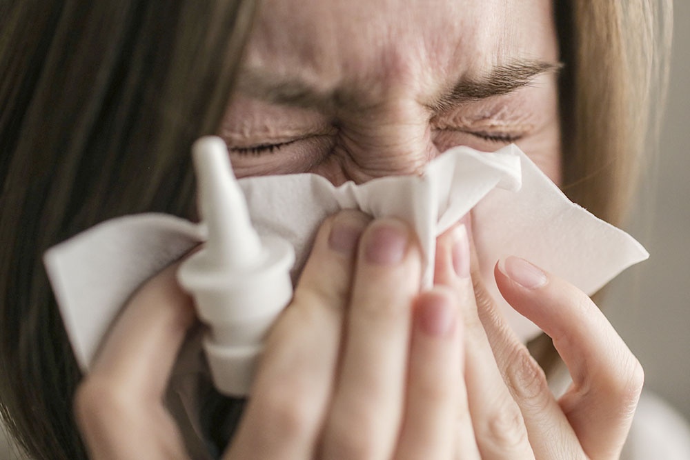 Девушка, страдающая аллергией, применяет препараты, уменьшающие симптомы аллергической реакции.