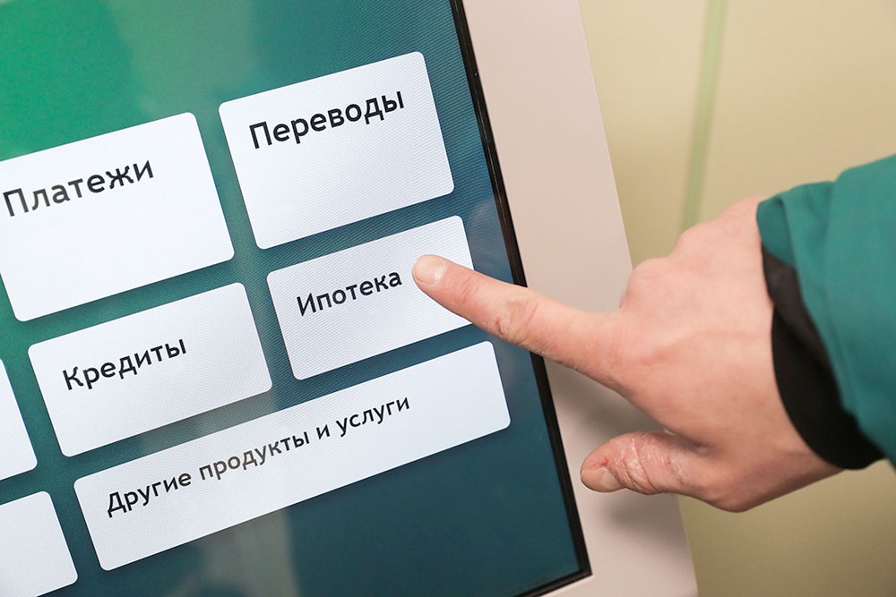 Клиент в банке нажимает кнопку "Ипотека" на терминале. Документы проверены, заявка готова к оформлению.