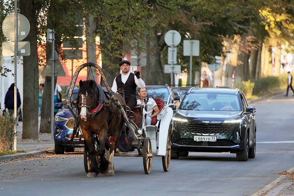 Конный экипаж и автомобиль на улице Суздаля.