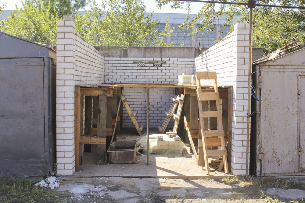 Кирпичный гараж: ворота с уплотнителями по всему периметру помогут сохранить тепло и избежать сквозняков.