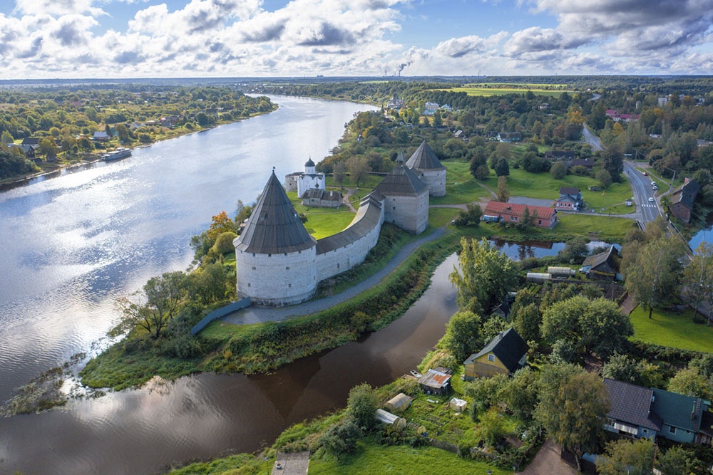 Староладожская крепость на берегу реки Волхов, каменные стены и башни.