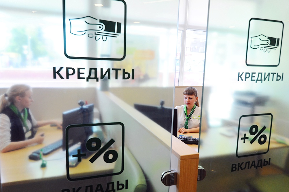 Сотрудницы банка сидят за стеклянными дверьми