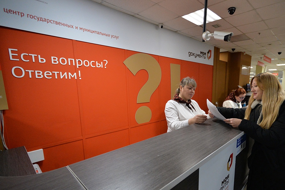 Сотрудник МФЦ консультирует посетителя по вопросам запроса справок.
