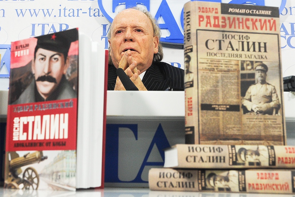Историк Радзинский сидит за столом среди книг