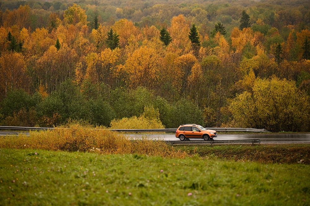 Автомобиль едет по дороге в Ленинградской области.