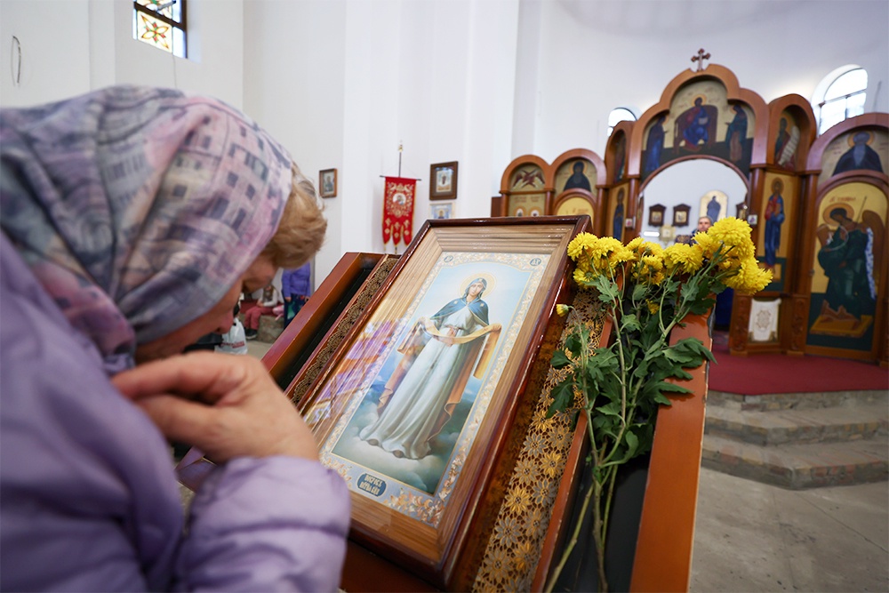пожилая женщина у иконы Покрова Богородицы