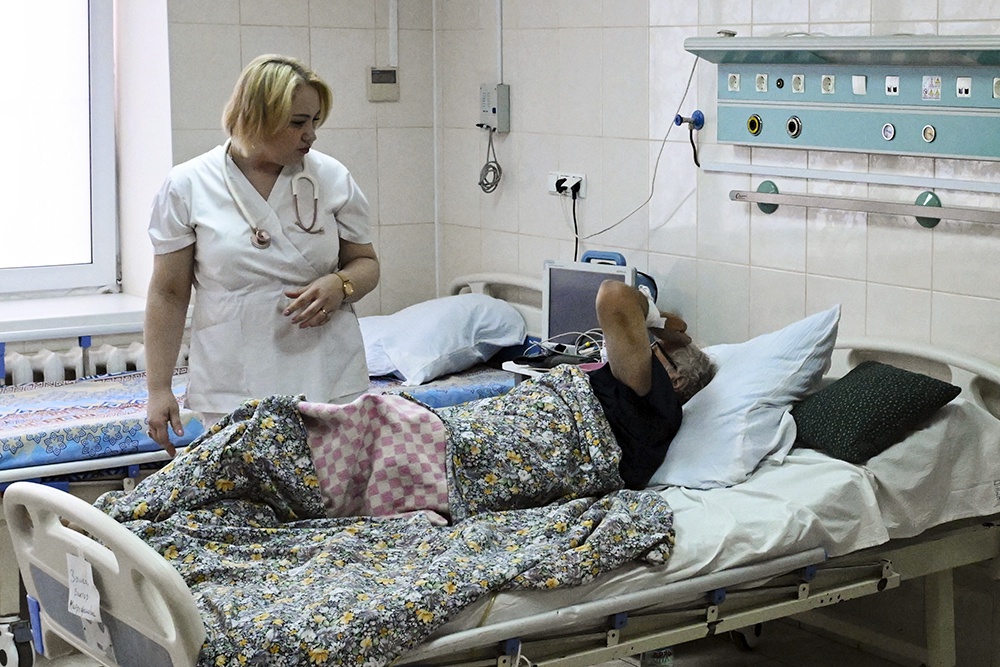 Медсестра у пациента в палате регионального сосудистого центра.