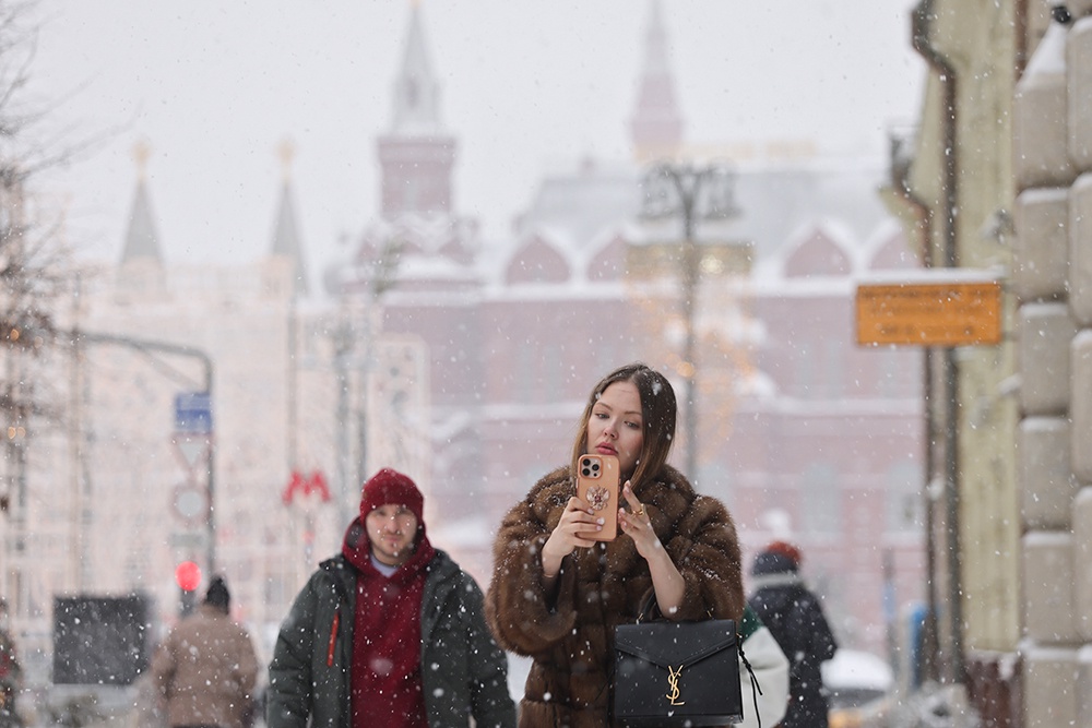 девушка делает селфи под снегопадом