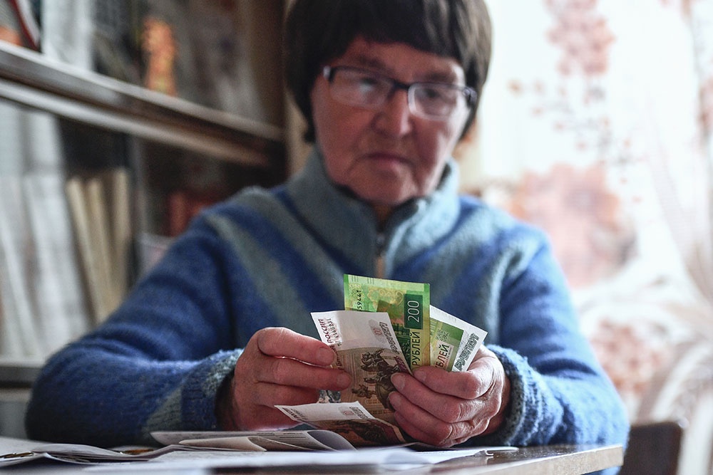 пожилая женщина держит в руках пенсию