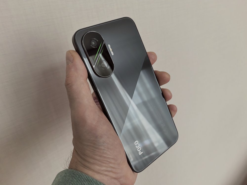 Cмартфон POCO F7 в руке. 