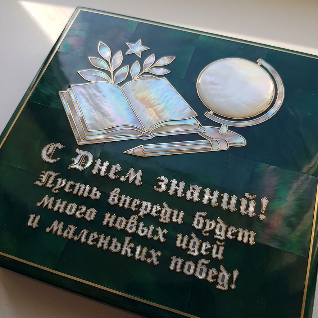 Объемные книга, перо и глобус на темном фоне с надписью: "С Днем знаний! Пусть впереди будет много новых идей и маленьких побед!".