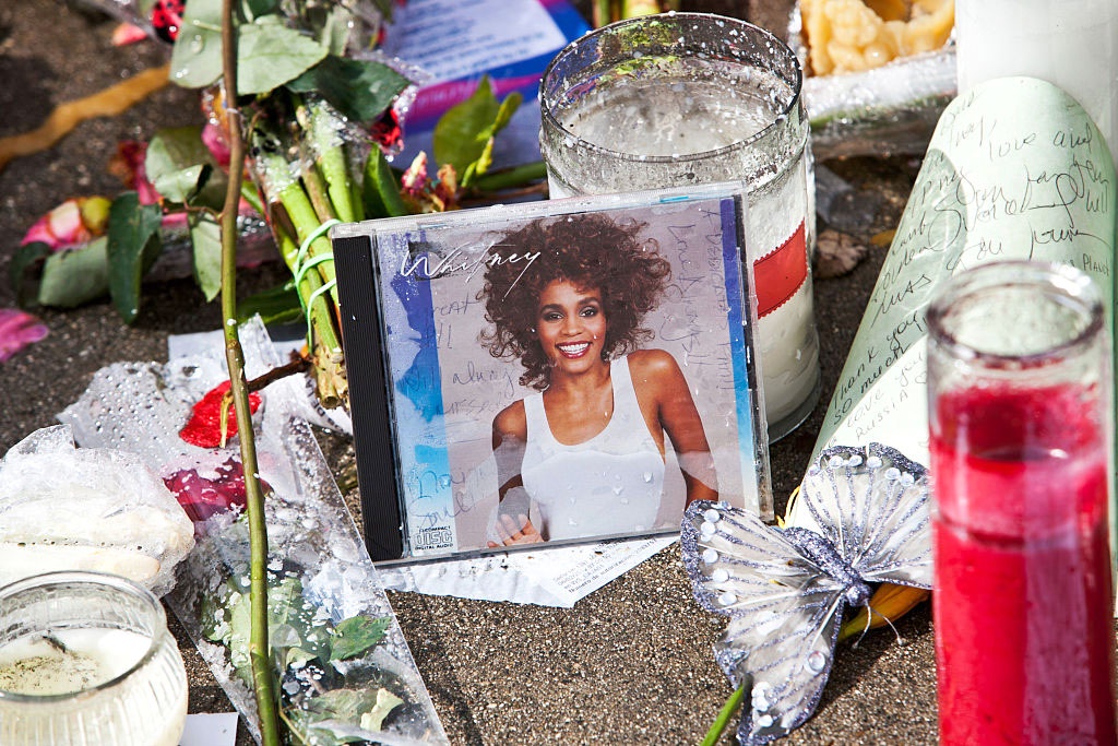 Уличный мемориал у отеля "Беверли Хилтон" с цветами и фотографиями в память об Уитни Хьюстон.