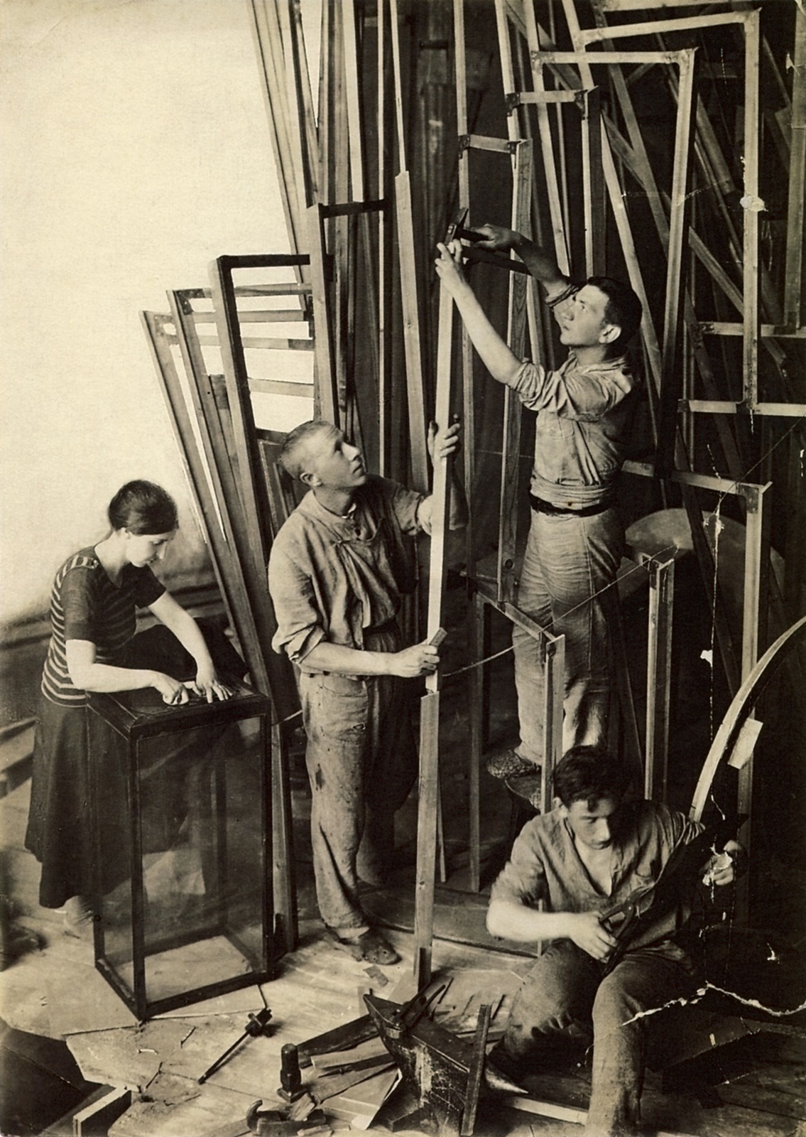 Владимир Татлин (стоит в центре) с ассистентами работает над макетом башни. 1920