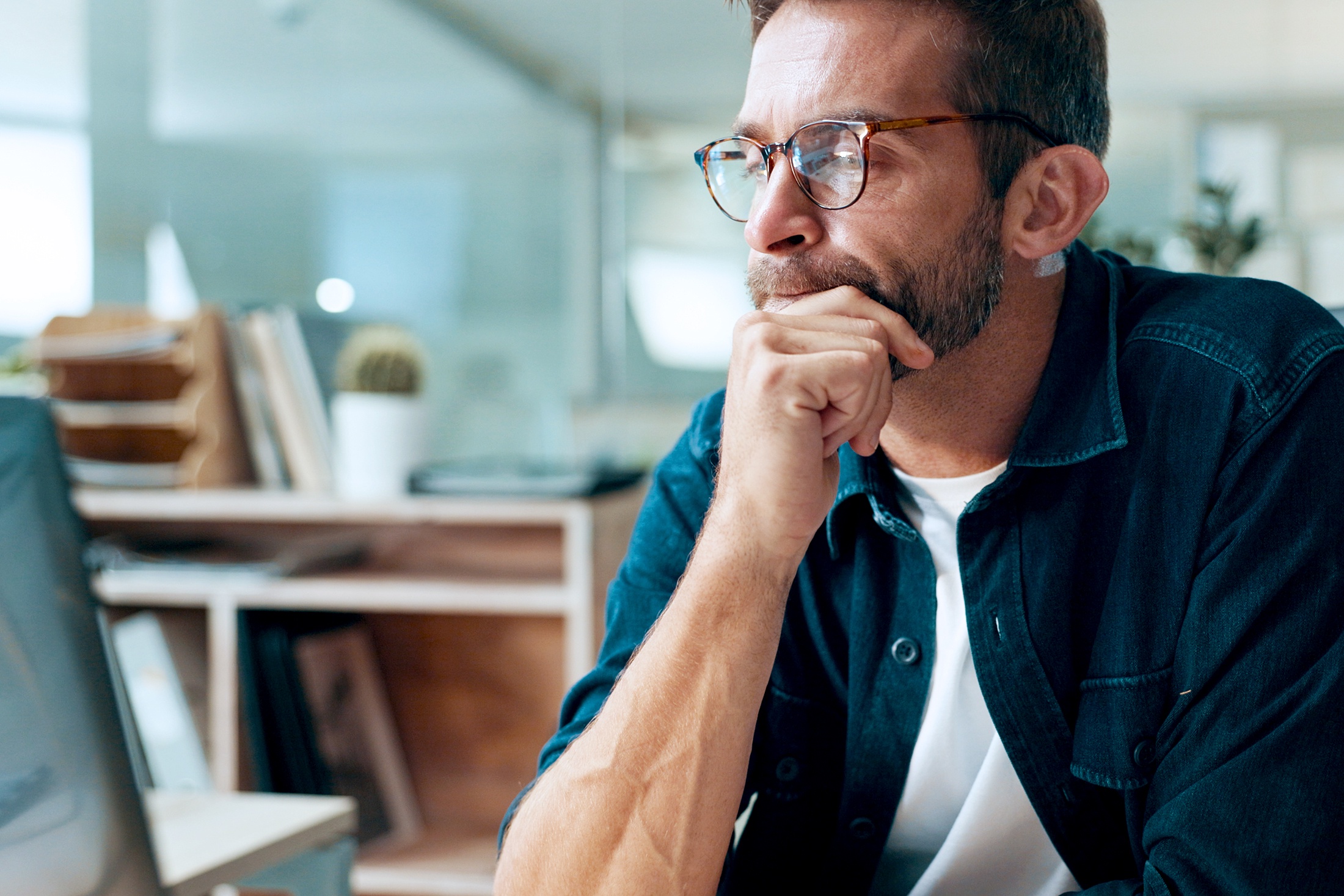 Мужчина сидит в кабинете и думает о кредите