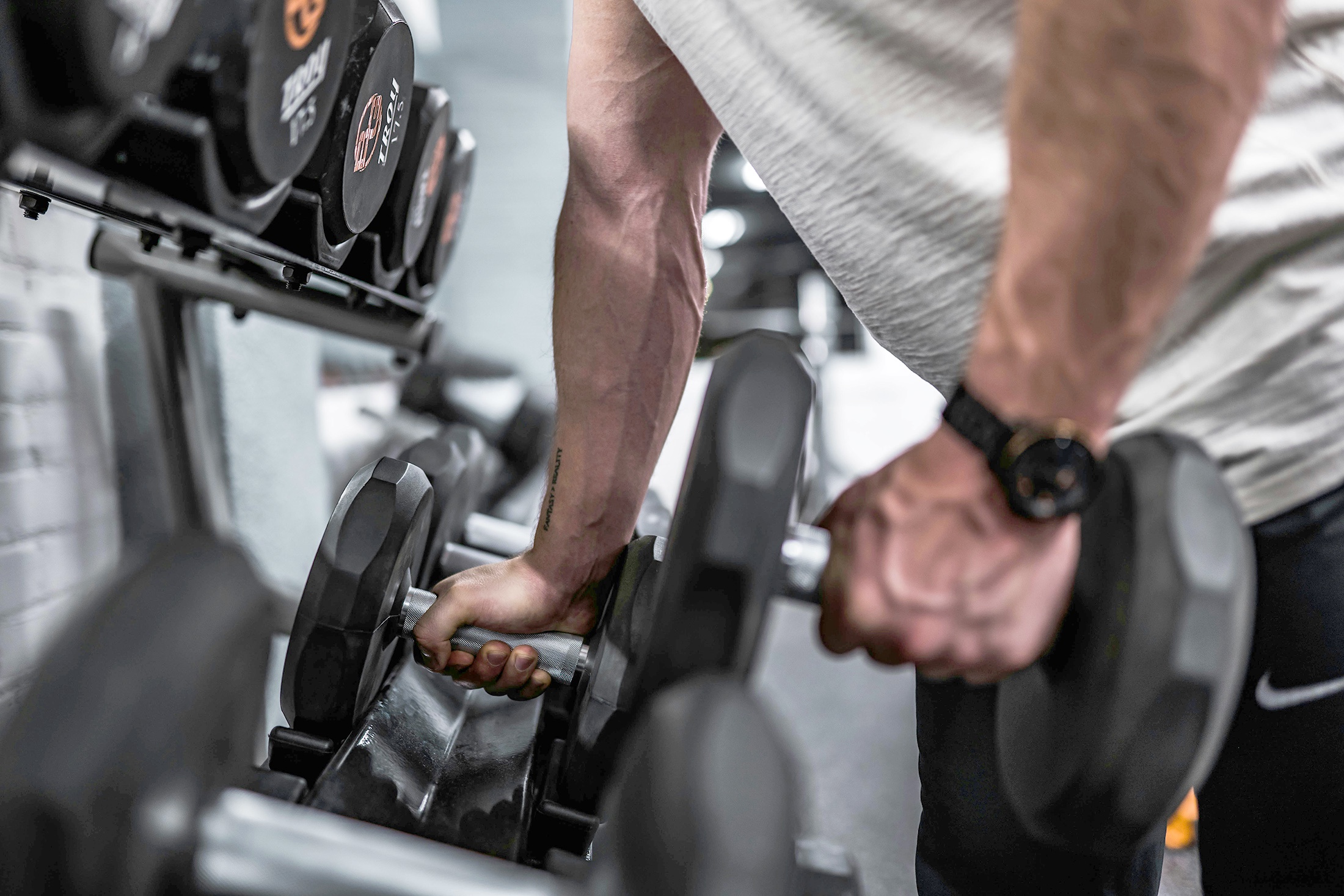 мужчина держит гантели