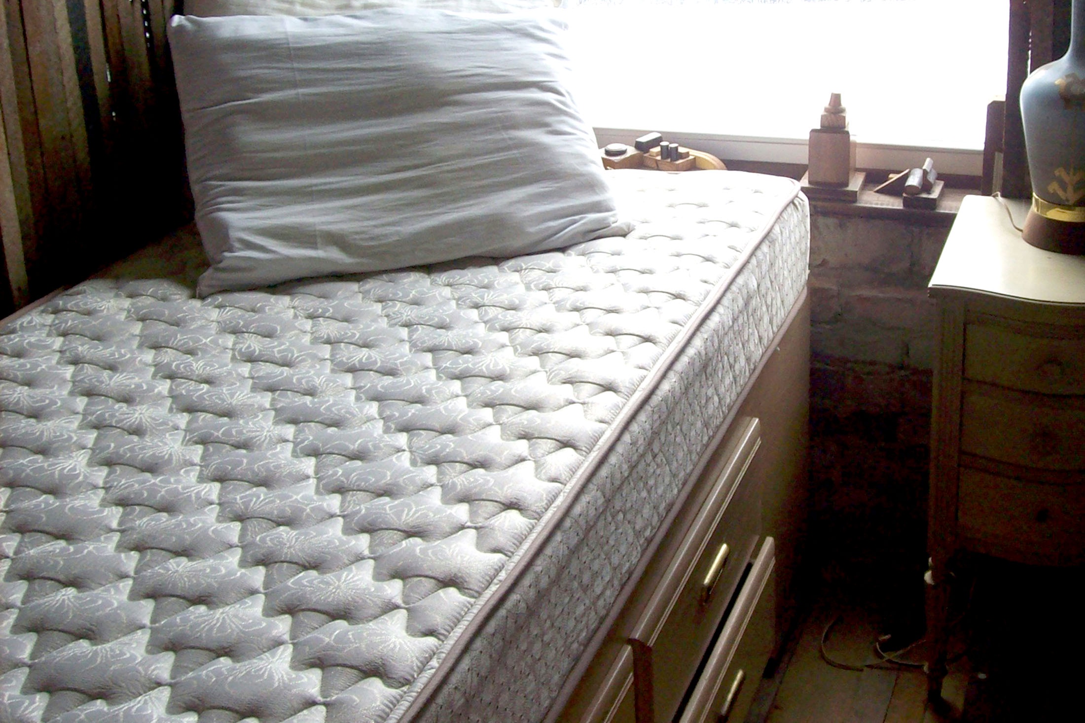 кровать с матрасом в спальне небольшой