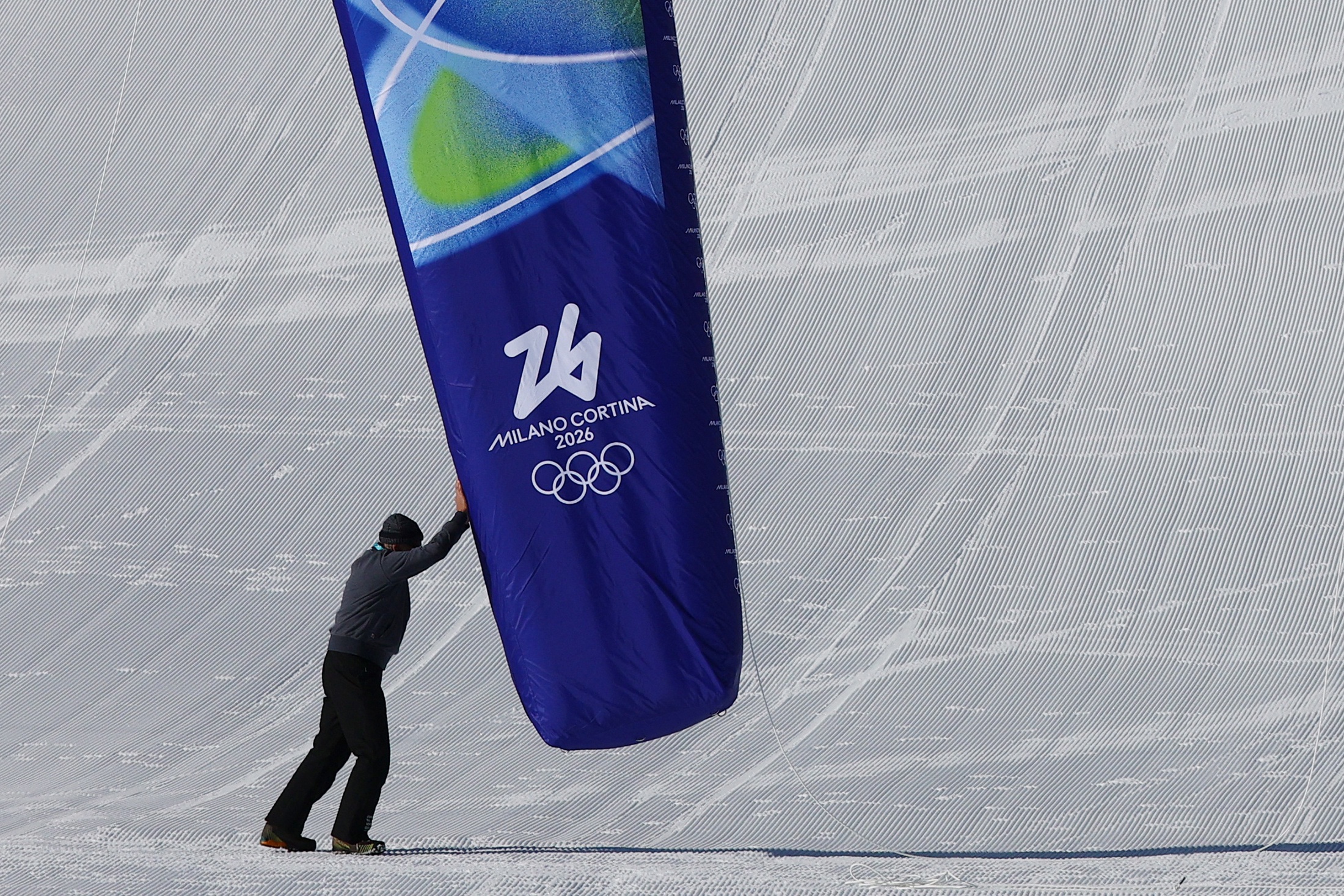 Сотрудник устанавливает флаг на лыжной трассе