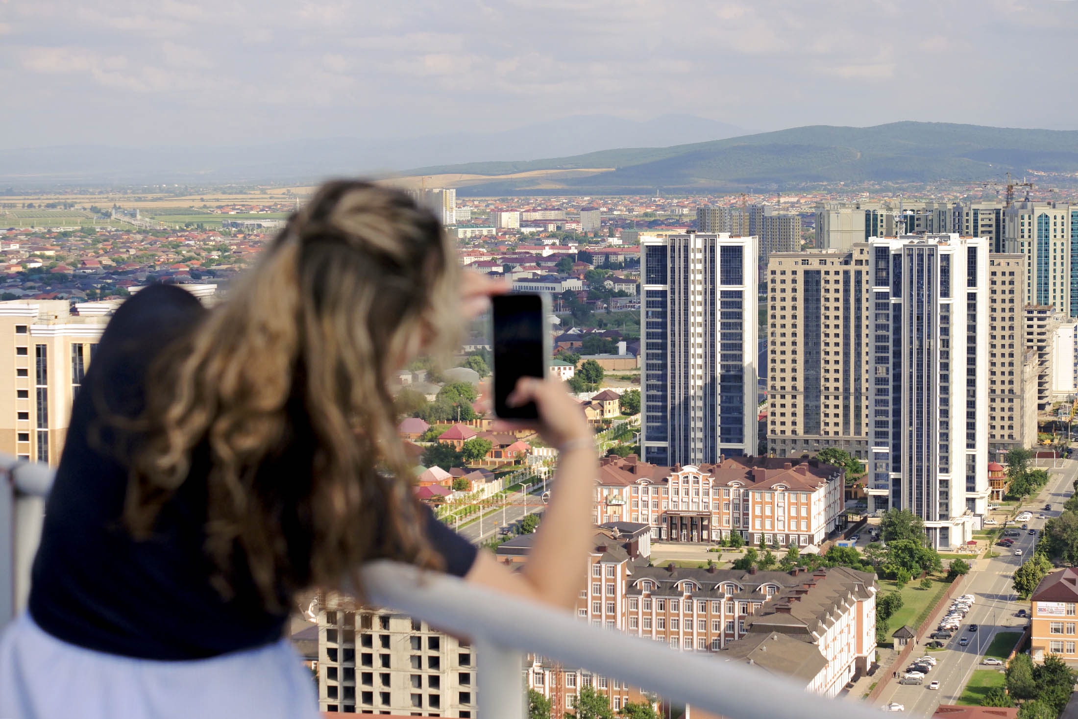 девушка снимает панораму города