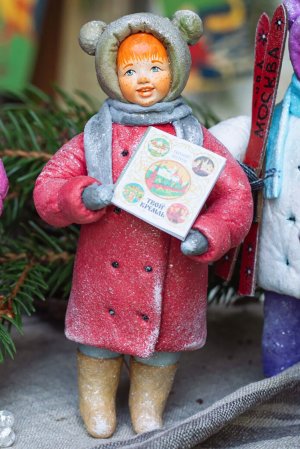 Винтажная елочная игрушка в виде девочке в зимней одежде.
