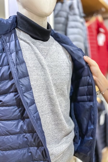 На манекене водолазка, свитер и легкий пуховик