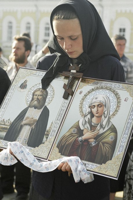 Женщина с иконами Пресвятой Богородицы и Серафима Саровского