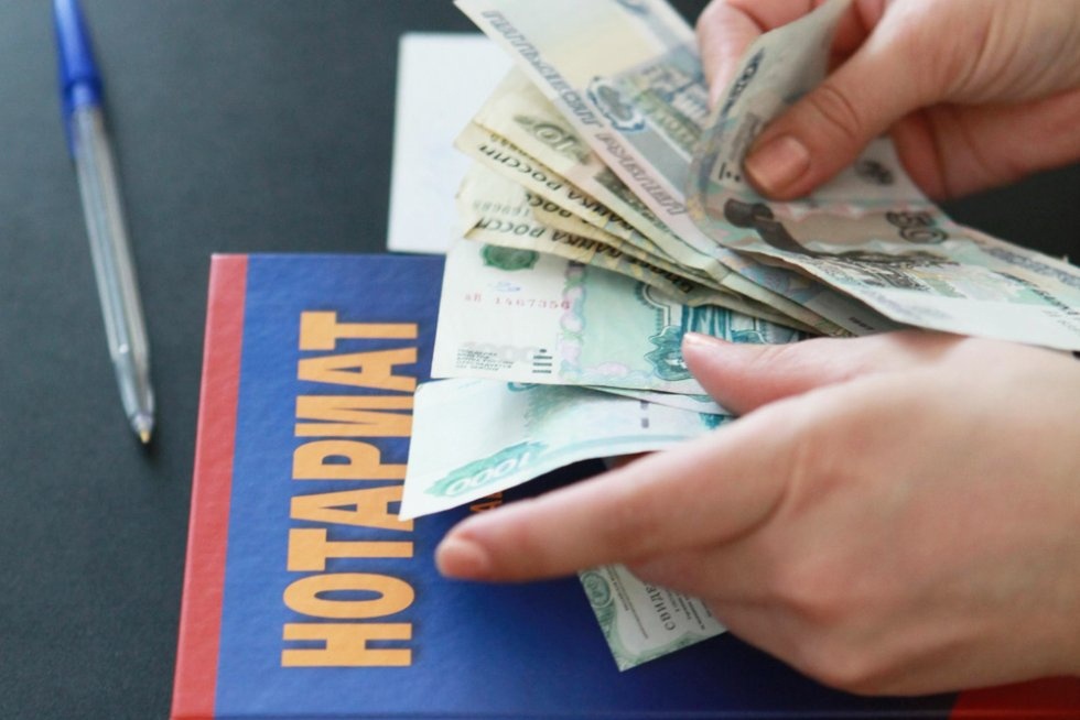 Деньги и книга нотариуса - оплата услуг нотариуса