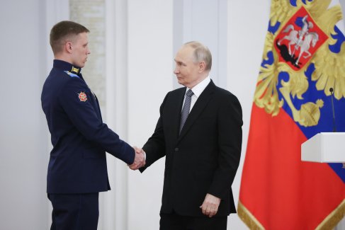 Владимир Путин поздравляет
с наградой младшего сержанта ВС РФ Михаила Тамбовцева.