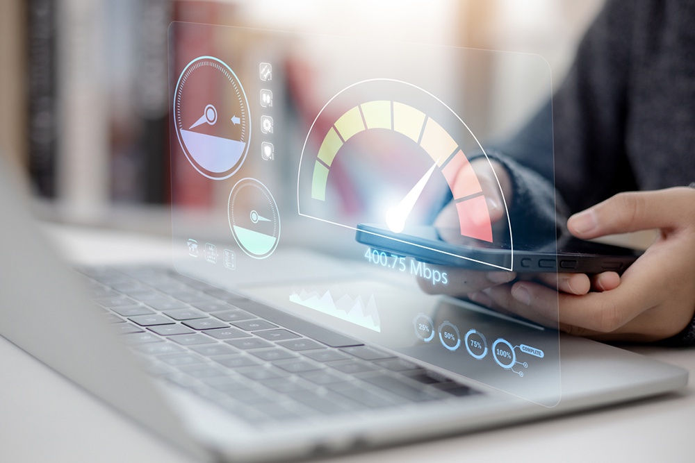 Человек проверяет скорость интернета на компьютере и смартфоне. 