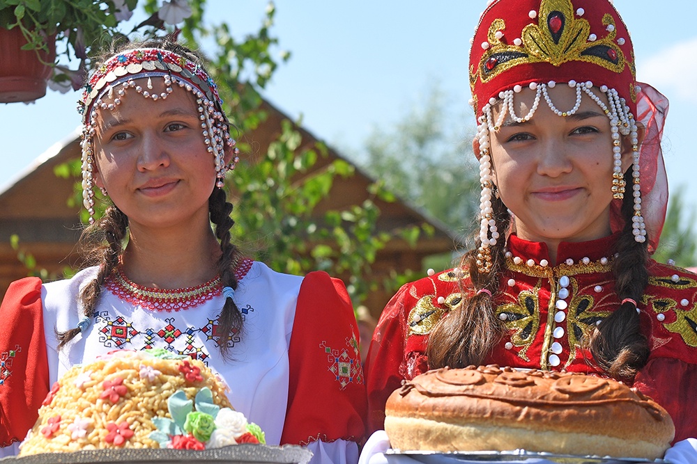 Девушки держат в руках блюда русской хни.