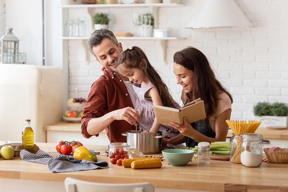 Семья готовит на кухне по книге рецептов