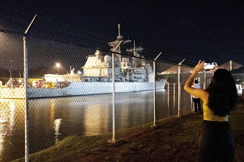 Зеваки наблюдают, как ракетный крейсер США проходит Панамский канал на пути к Венесуэле.