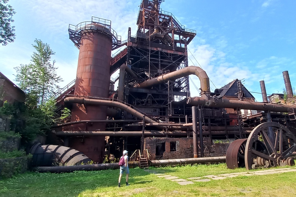 Старый водовод упирается в подпорную стену плотины. За трубами и лестницами скрыта домна 1930 года.