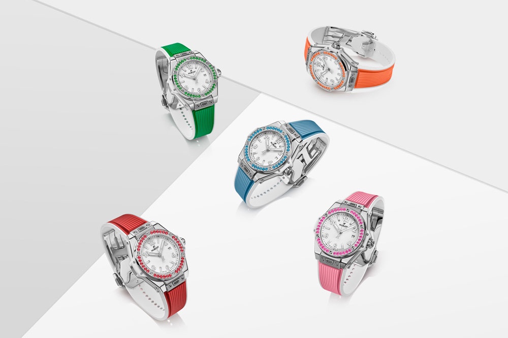 Часы Hublot Big Bang One Click Joyful 33mm инкрустированы цветными драгоценными камнями и посажены на каучуковый
ремешок им в тон.