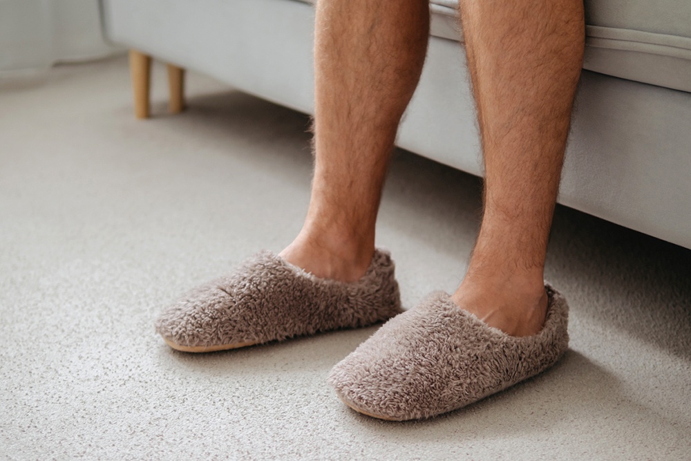 Мужчина в коричневых тапочках